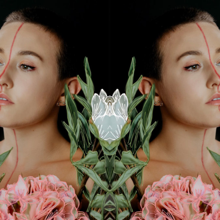 mirror image of short hair woman with line down face and flowers surrounding her